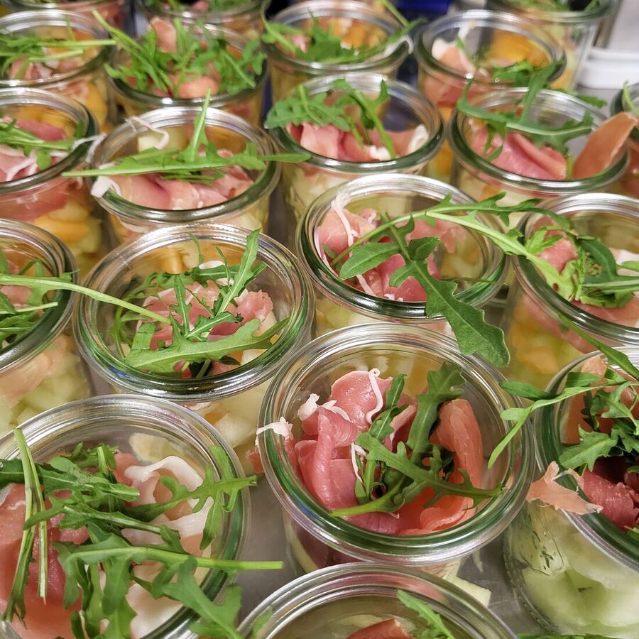 Salat mit Rucola und Schinken im Glas serviert
